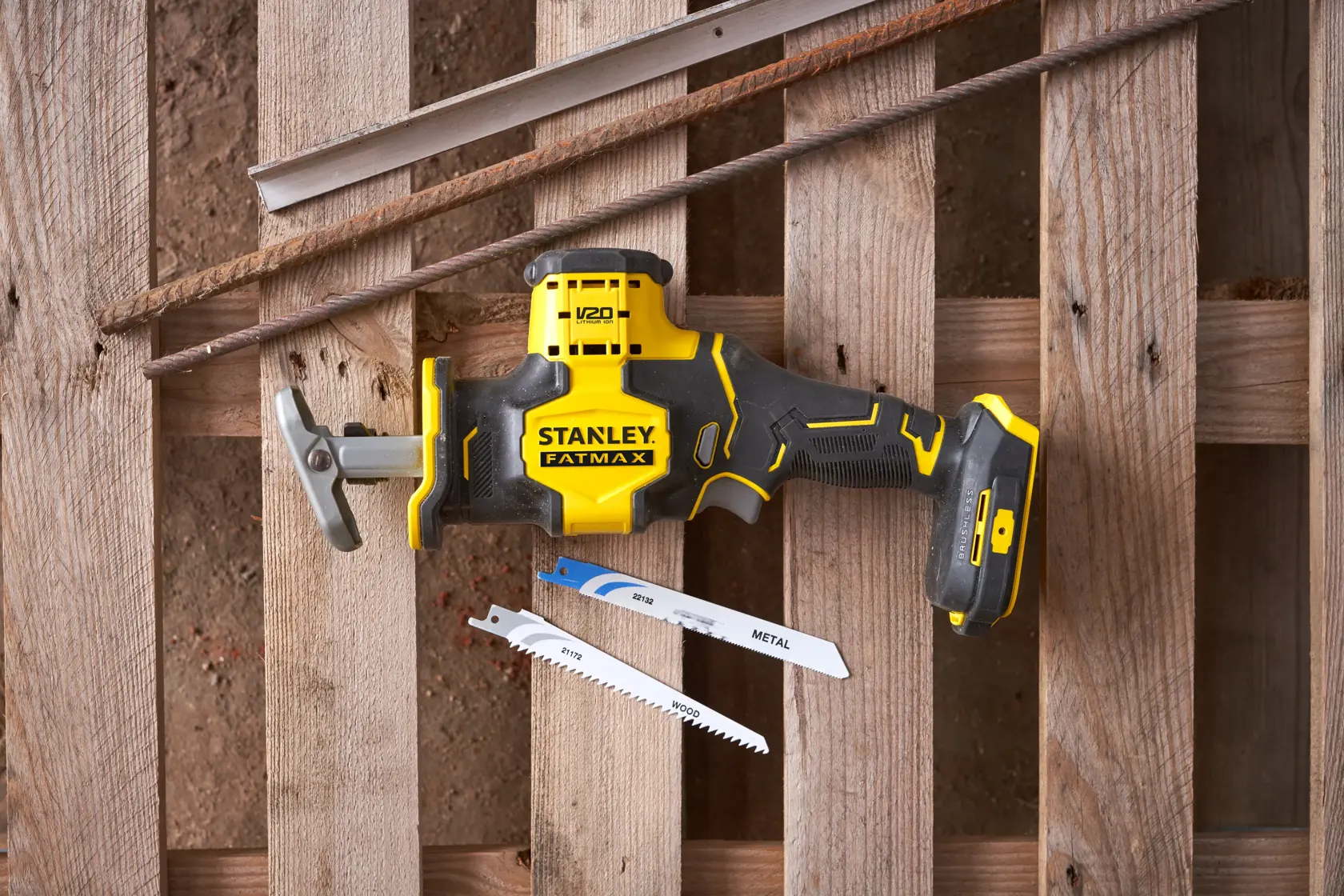 Scie sabre Stanley SFMCS305B jaune et noire présentée avec deux lames de scie sur fond en bois.