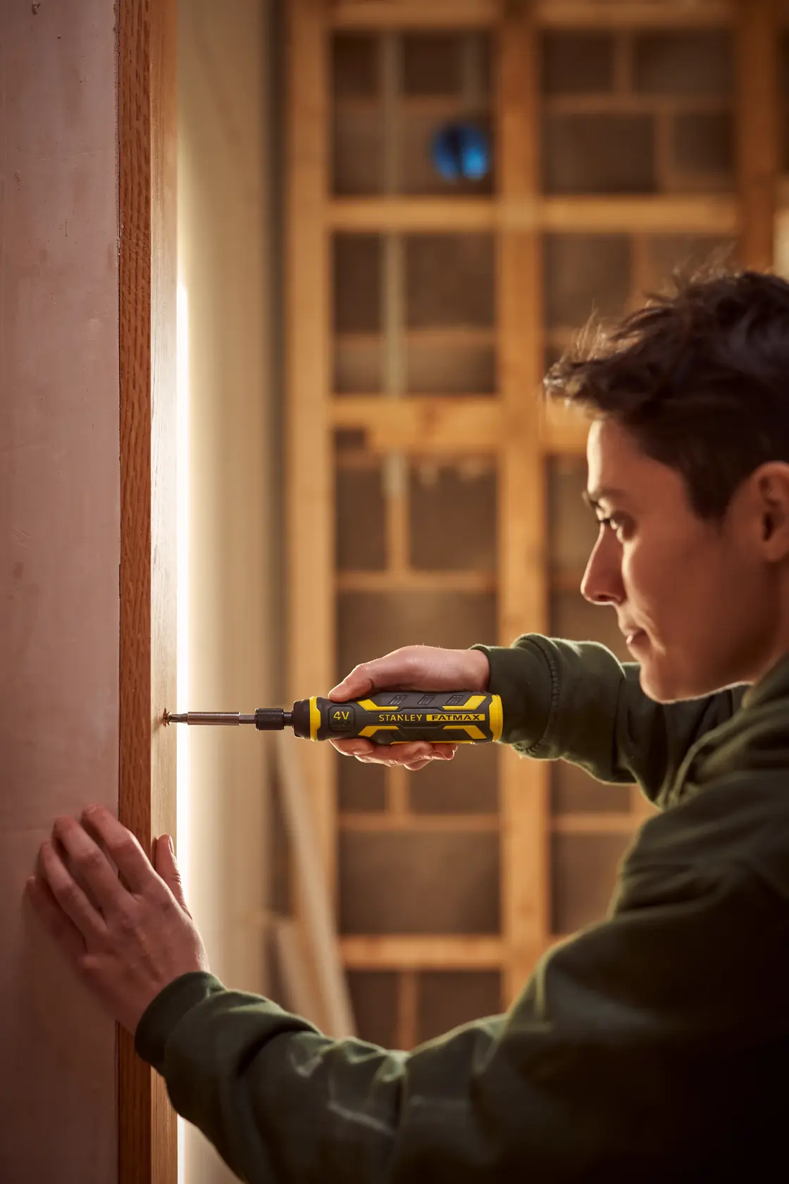 Stanley FMHT66719-0 tournevis électrique utilisé par une personne pour fixer une vis dans un cadre en bois.