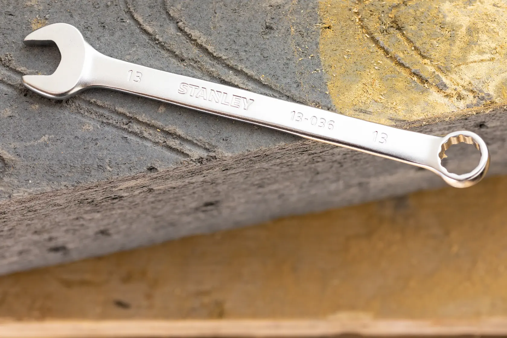 STANLEY FMMT13042-0 combination wrench in silver finish, placed on textured concrete surface.