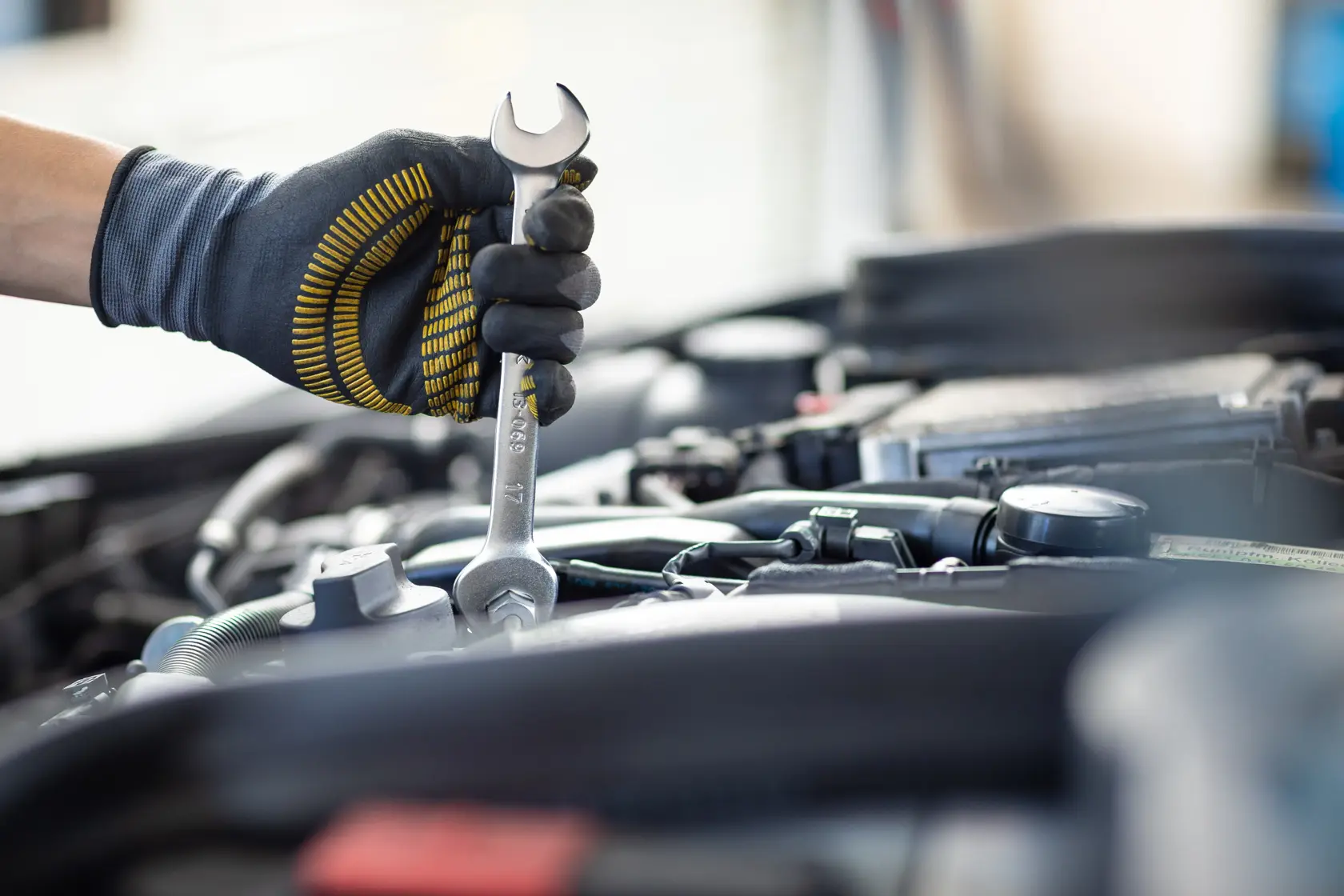 STANLEY FMMT13066-0 wrench used on car engine, close-up photography of tool and gloved hand.