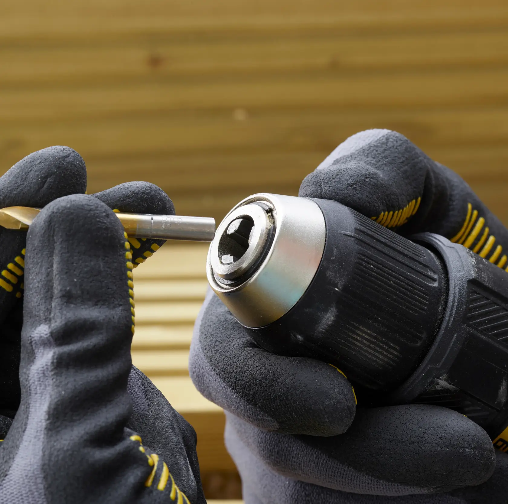 STANLEY SFMCD710D2K, SFMCD710D2K-QW perceuse, insertion foret, mains gantées, photographie