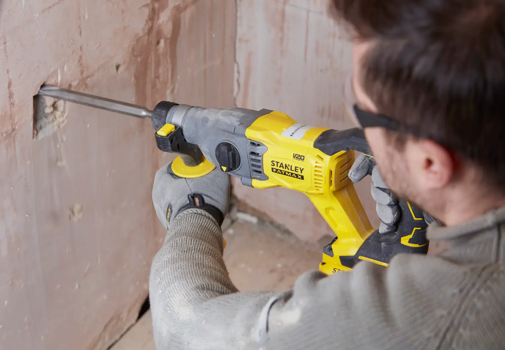 Photographie d'une personne utilisant un perforateur STANLEY SFMCH900B sur un mur.