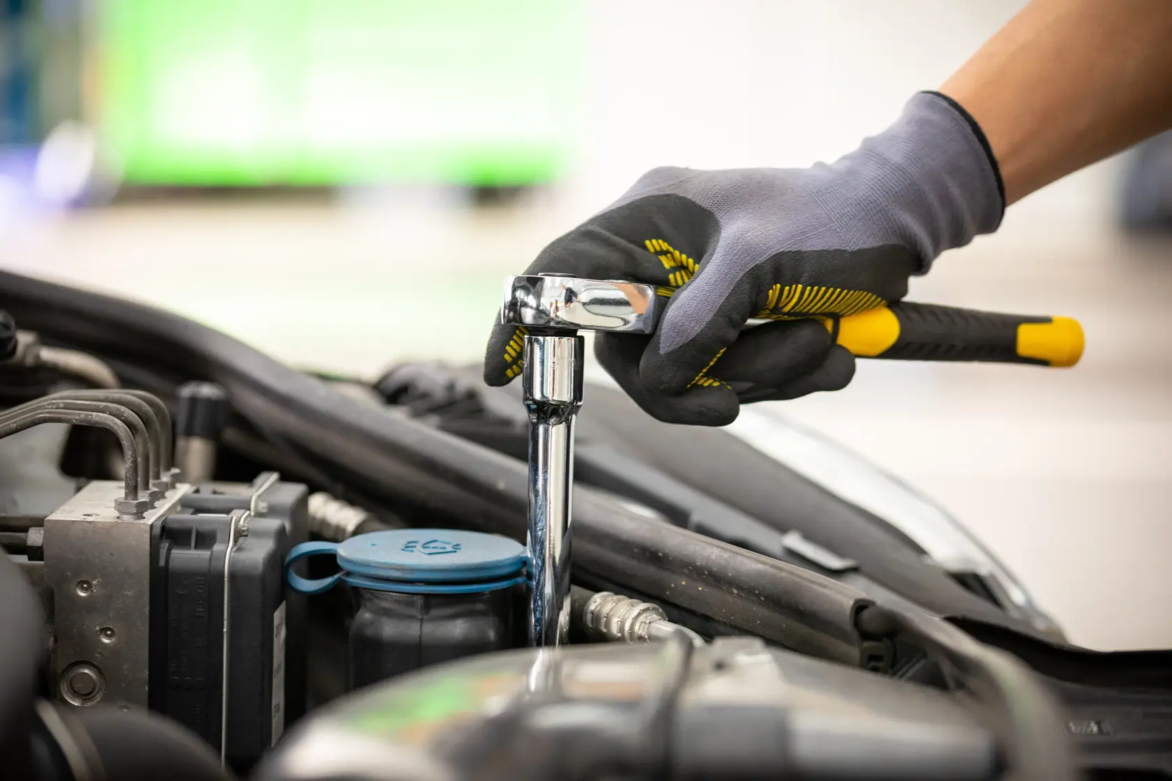 Photo of STANLEY STMT88930-0 ratchet wrench in use, tightening bolt in car engine compartment.